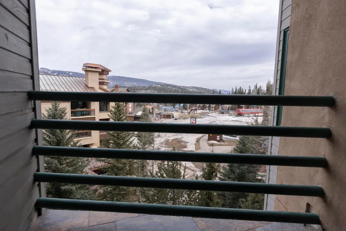 A breathtaking perspective from the private deck, this image showcases panoramic mountain views, surrounding trees, and the tranquil ambiance of the outdoors. The scene captures the essence of enjoying coffee, sunset, or starlit evenings while taking in the grandeur of the Needles Mountains and ski slopes.